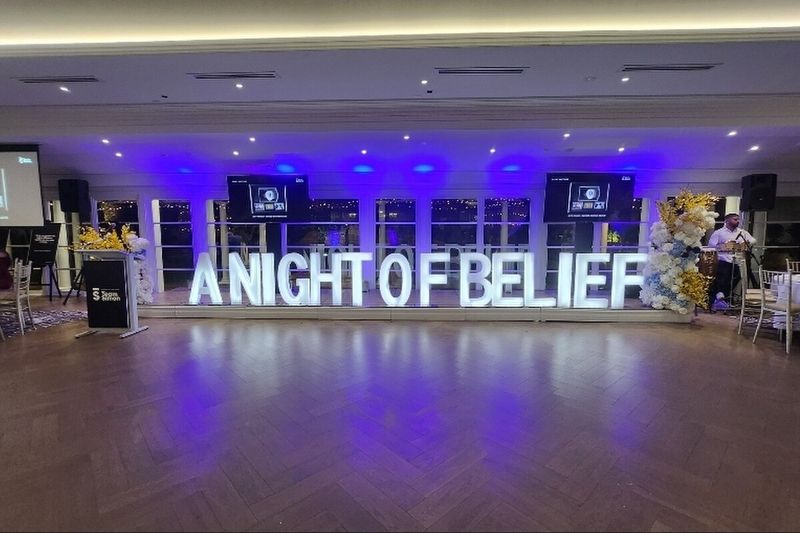 Marquee letters spelling A NIGHT OF BELIEF at a corporate event