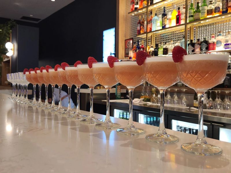 Bartender pouring drinks at a lit event bar