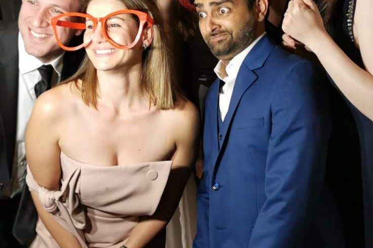 Two guests in formalwear posing with novelty glasses at the photo booth