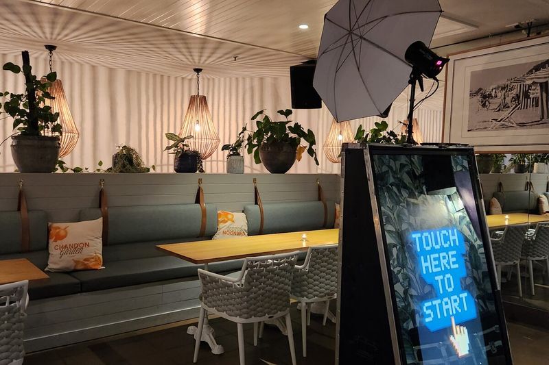 Mirror booth signed and ready with a touch-to-start prompt