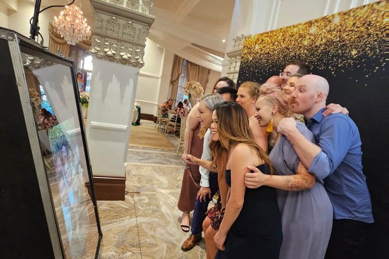 Guests crowding into the mirror booth together in a marble foyer