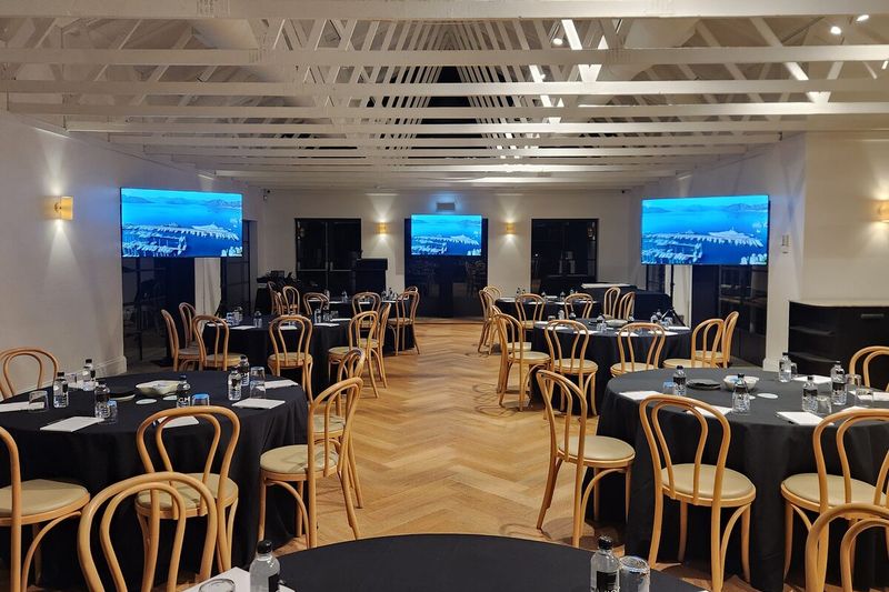 Ballroom with parquet dance floor clear beside banquet tables