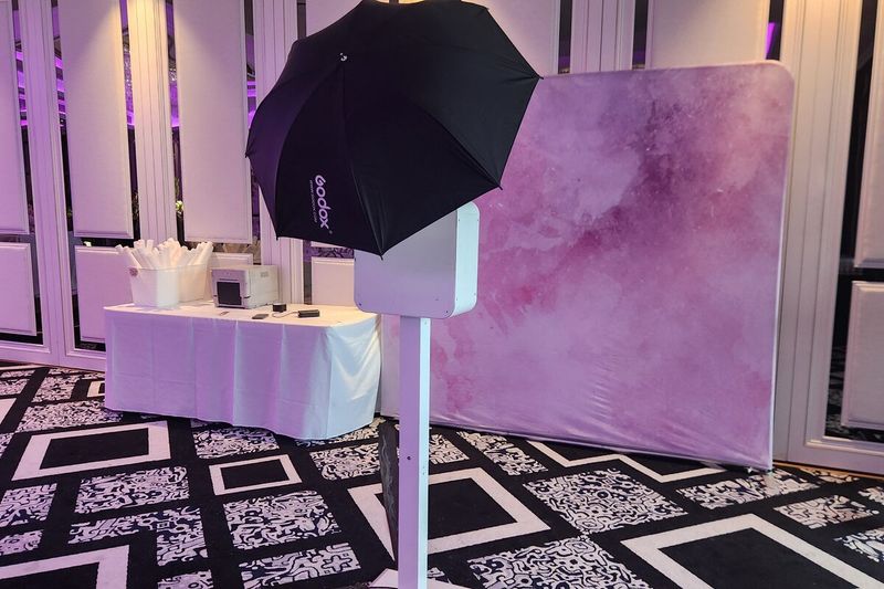 Open-air booth and pink watercolour backdrop across a ballroom