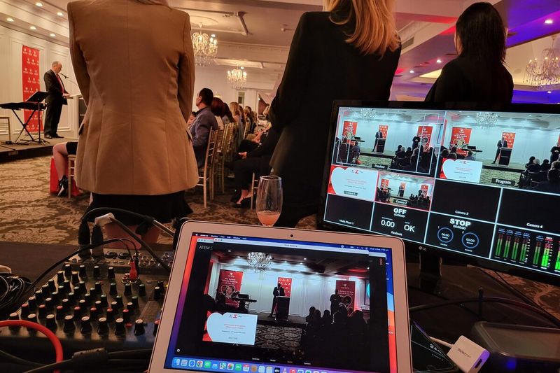 Technician at the audio desk with multiview monitors during a live corporate event