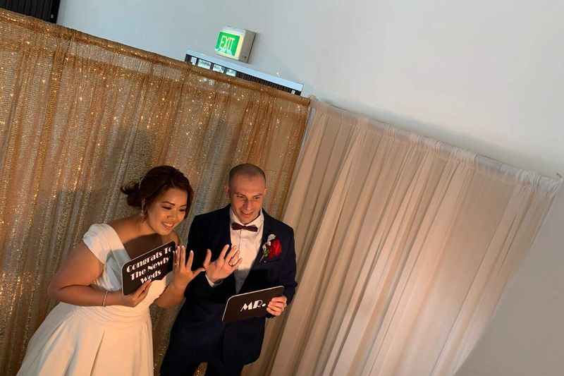Bride and groom holding sign boards at the photo booth