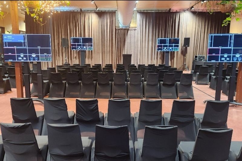 Theatre-style seating facing dual presentation screens