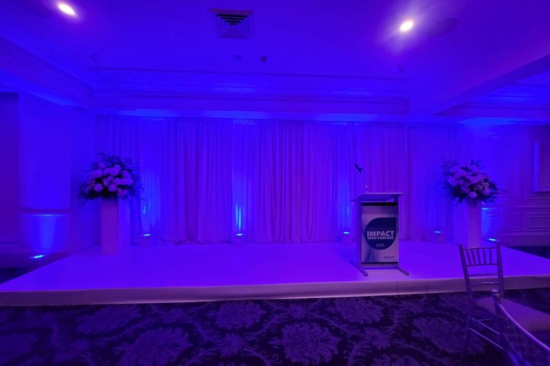 Draped wall washed in purple uplighting in a reception room