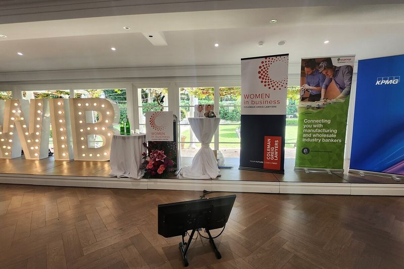 Marquee letters spelling WIB beside corporate banners