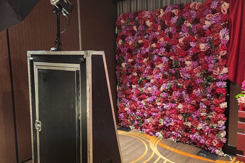 Mirror booth set against a red rose flower wall