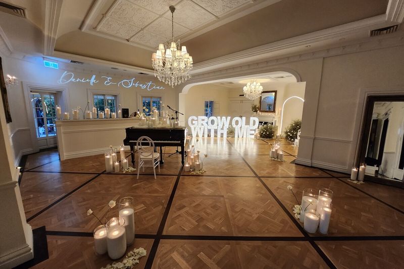 Script monogram gobo projected above an arch beside lit marquee letters