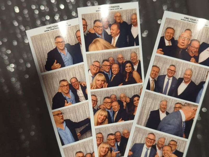 A hand holding printed photo booth strips