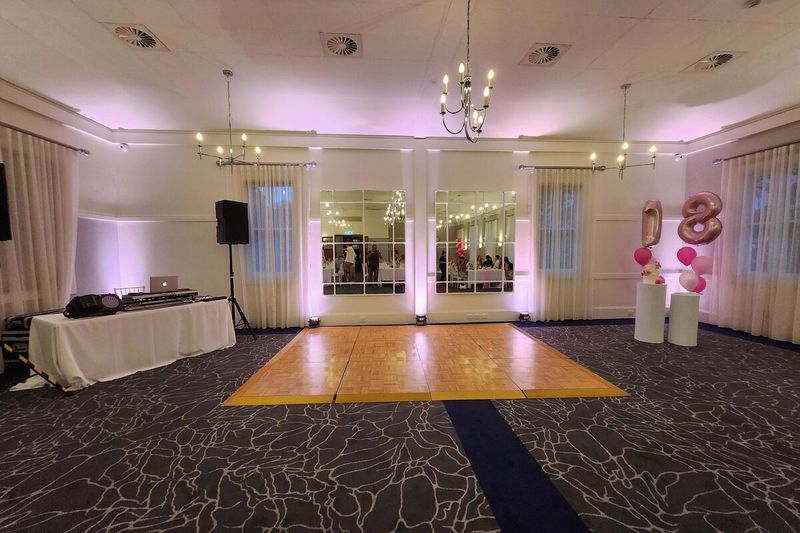 Function room with a gold dance floor laid and lit before guests arrive