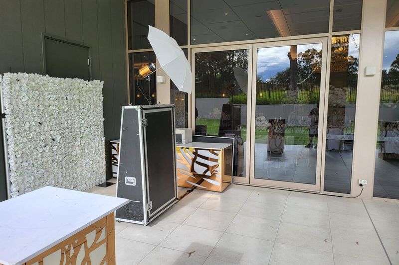 Mirror booth beside a white flower wall next to terrace doors