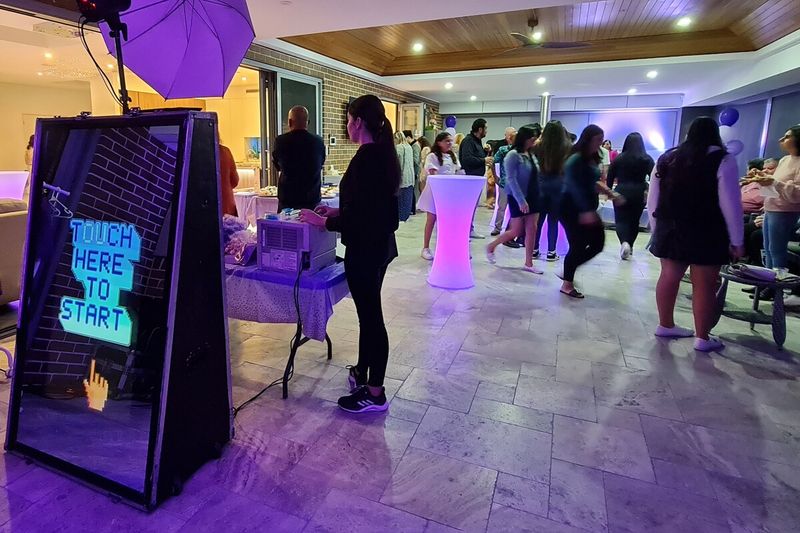 Mirror booth with an attendant on hand while guests mingle at a private party