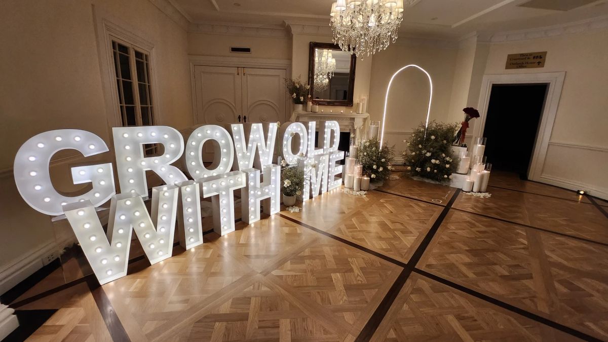 Light up letters in Sydney: marquee letters spelling GROW OLD WITH ME in a wedding room with a parquet floor