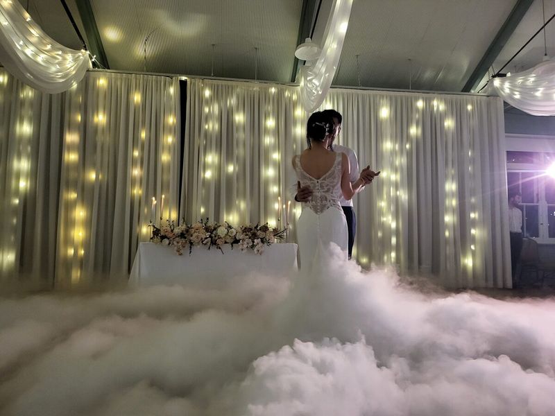Bride in a low fog cloud in front of a fairy-light backdrop