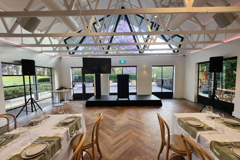 Screens and speakers set up under a white event pavilion
