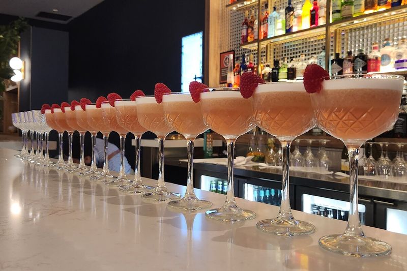 Row of garnished cocktails lined along the bar ready for guests