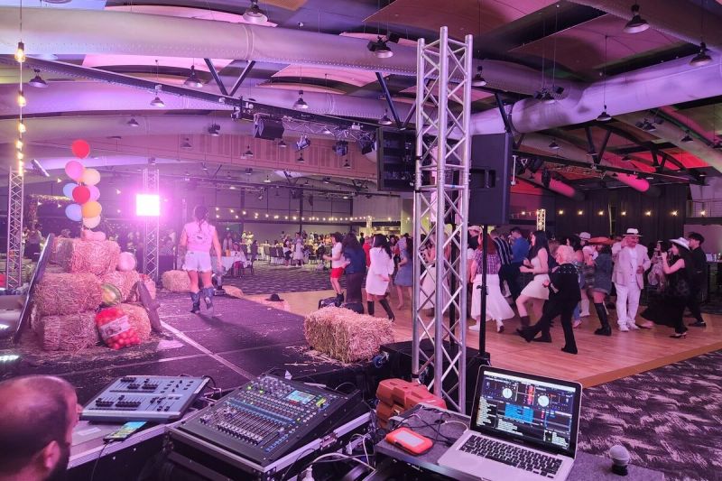 DJ desk in the foreground with a corporate function under way behind