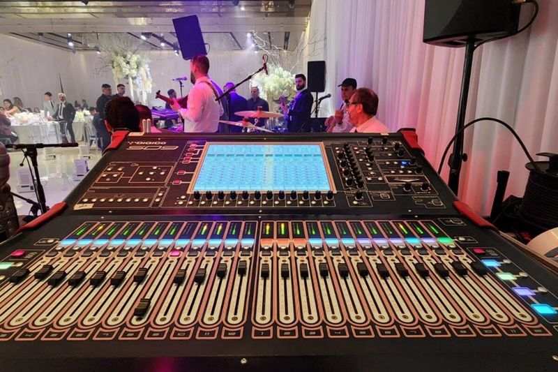Large audio mixing console set up with a lit function room behind