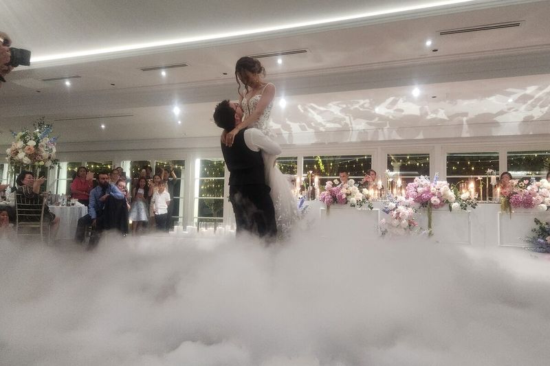 Bride and groom dancing surrounded by a low dry ice cloud